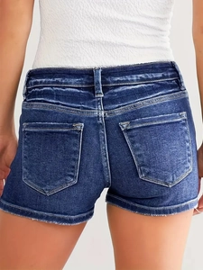 Rear view of distressed blue denim shorts with low-waisted fit and frayed raw hem detailing