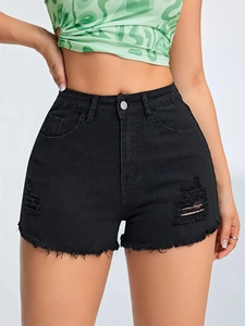 Detail showing distressed ripped texture and raw hem on slim-fit black denim shorts