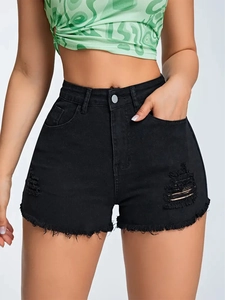 Close-up of black ripped denim shorts with raw hem and distressed cat-whisker details