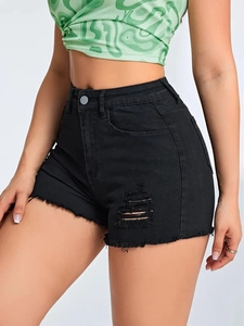 Detailed close-up of slim fit black denim shorts with ripped holes and frayed hem