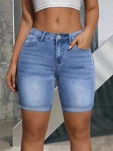 Gros plan détaillé du short en jean bleu foncé avec moustaches et ourlet à revers net