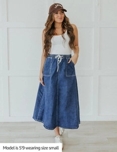 Détail d'une jupe en jean délavé à taille haute avec cordon de serrage et grandes poches
