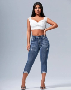 Detail showing distressed denim capris with knee rips and frayed edges on slim fit jeans
