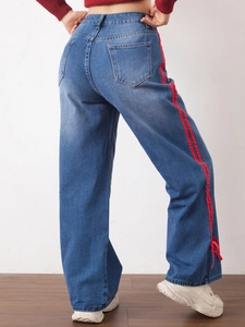 Detailed back view of mid-blue denim jeans featuring side red stripes and bow ribbons