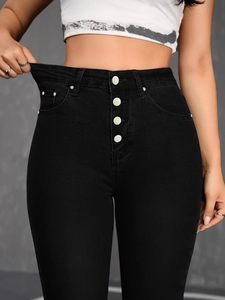Detail of high waist black stretch jeans featuring a four-button fly and elastic denim fabric