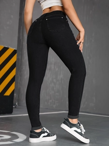 Detail view of high waist skinny black jeans showing back pockets and slimming fit