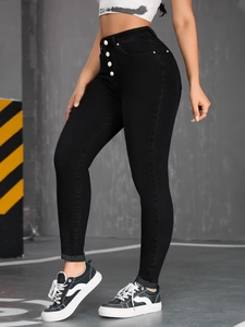 Detail of high waisted black stretch jeans featuring a four-button fly and slim fit design