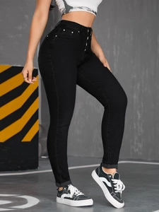 Detail of high waisted black skinny jeans with multi-button closure and slim fit design