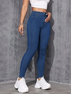 Jean skinny bleu foncé taille haute pour femme avec crop top blanc et baskets à semelle épaisse
