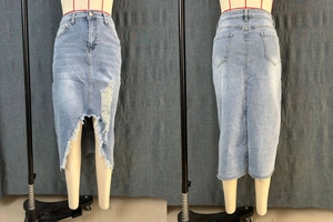 Close-up of light blue denim midi skirt with distressed hem and frayed tassel details