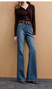 Detail of slim-fit flared jeans in dark blue with central seam and frayed hem edges
