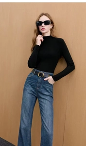 Detail of blue washed stretch denim flared jeans with frayed edges and double breasted waist