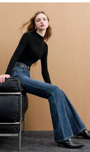 Detail of high waist flare jeans with front seam stitching and vintage blue wash finish
