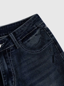Detail of dark blue flared jeans with contrast stitching and wash texture