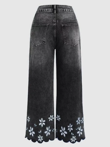 Detail of white flower embroidery and wavy scalloped hem on high waist grey denim jeans