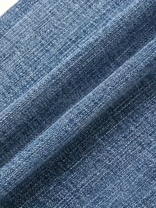 Macro texture of blue denim fabric with reinforced weave and vintage washed embroidery detail