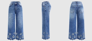 Close-up of white daisy embroidery and scalloped hem on high-waist blue denim jeans