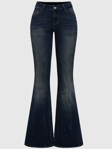 Close-up of high-waist flared jeans featuring vintage wash denim and classic metal button detail