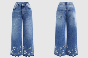 Detail of white daisy embroidery and scalloped hem on dark blue wide-leg jeans