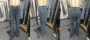 Detail view of high waist flared jeans with double buttons and vintage whiskers