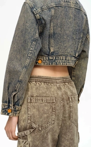 Close-up of vintage snow wash denim jacket with cropped cut and heavy texture details