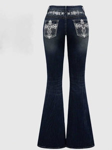 Detail view of gothic white embroidery and rhinestone accents on the back pockets of flare jeans
