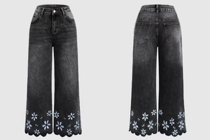 Detail of daisy embroidery and scalloped hem on black wide-leg cropped jeans