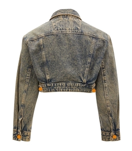Detail of vintage acid wash denim jacket back with blue-brown mottled texture