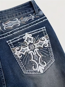 Women's flare jeans featuring heavy cross embroidery and rhinestone studs on back pocket