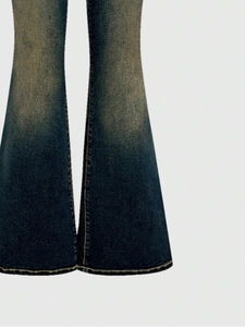 Detailed macro view of flared jeans bottom featuring yellow wash and golden hem stitching