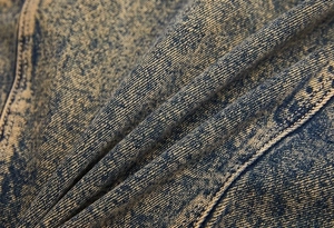 Close-up of vintage snow wash denim fabric texture on a retro oversized jean jacket