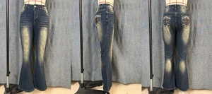 Detail view showing retro washed denim flare jeans with Lost Souls embroidery on back pocket