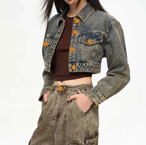 Detail of vintage washed denim jacket with cargo pockets and retro yellow mud wash finish