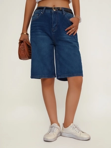 Detail of high-waisted dark blue denim bermuda shorts with a slim black leather belt