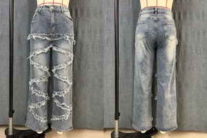 Détail du jean taille haute avec franges blanches et texture en denim délavé vintage