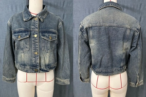 Detail view of vintage dark blue washed denim jacket with metal buttons and chest pockets