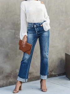 Détail du jean bleu taille haute avec taille croisée et ourlets larges à revers tendance