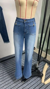 Detail of high waisted light blue jeans showing large patch pockets and metal buttons