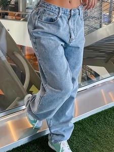 Détails d'un jean droit délavé bleu clair à taille haute avec des textures vintage