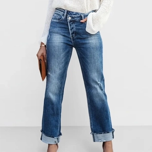 Détail du jean droit taille haute avec taille croisée et larges revers au bas du pantalon