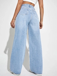 Detail view of light blue wide-leg jeans with back pockets and gold chain accessory