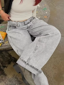 Détail d'un jean large à taille haute en délavage acide gris clair avec ourlet revers
