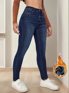 Dettaglio dei jeans slim a vita alta con fodera termica in pile grigio scuro invernale
