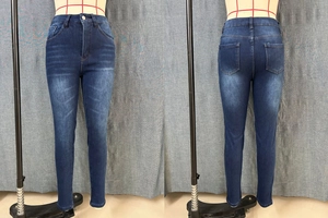 Dettaglio jeans slim a vita alta con lavaggio vintage e trama a baffi di gatto distressed