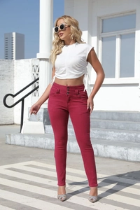 Détail d'un jean skinny taille haute bordeaux avec une fermeture unique à trois boutons