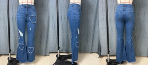 Detail of high waist flare jeans with heart-shaped distressed cutouts and frayed hems