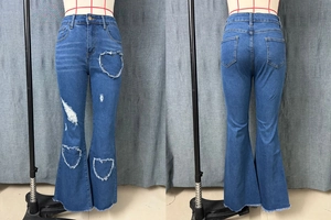 Detail of high-waisted flare jeans with heart-shaped cutouts and frayed hem edges
