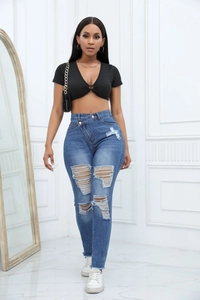 Détail de jean taille haute déchiré avec taille asymétrique unique et texture denim usée