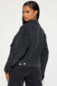 Détail de la couture arrière et de la boucle en métal argenté d'une veste en jean noire