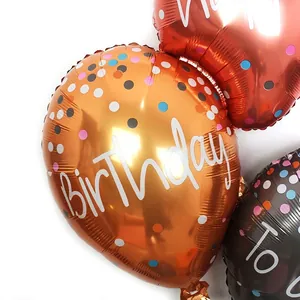 Golden and red metallic Happy Birthday foil balloons with colorful polka dots